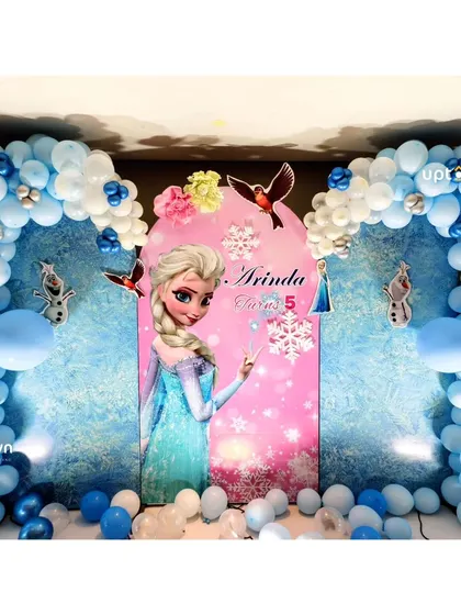 This Frozen setup uses blue and white balloon arches to create an icy, magical feel.