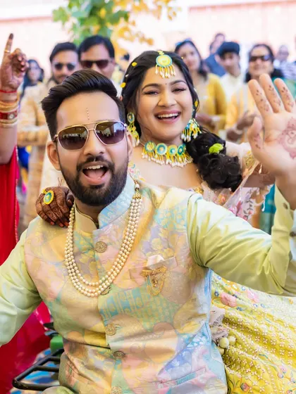 A fun moment with the bride and groom during the Haldi festivities. Her makeup is waterproof and smudge-proof, ready for all the fun and games.
