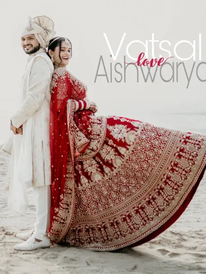 A fun and playful shot of the couple on the beach. The bride's joyful expression and the full display of her lehenga make this a memorable and happy portrait.