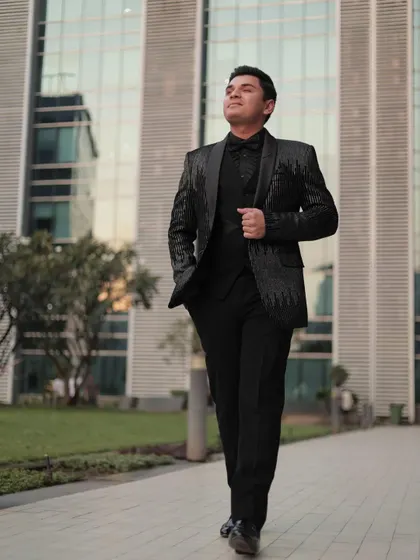 Another shot of our client looking dapper in the sequin tuxedo. The modern architecture in the background complements the sleek, contemporary design of the suit.