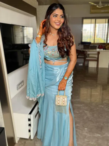 A full-length view of the client, ready for her event. The open hairstyle with soft curls balances the detailed embroidery of her modern lehenga.