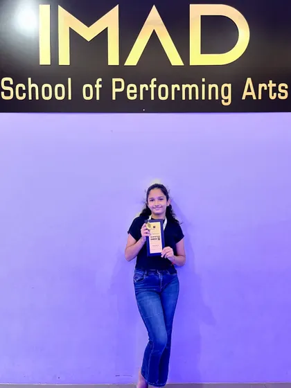 Another shot of our proud winner, standing in front of the IMAD logo. We love celebrating our students' successes.