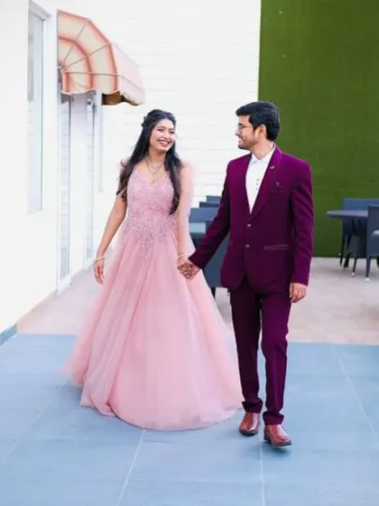 Modern elegance for a pre-wedding shoot or reception. This rich wine-colored tuxedo offers a contemporary twist on formal wear, perfectly complementing her beautiful pink gown. I help couples find looks that match their style and story.