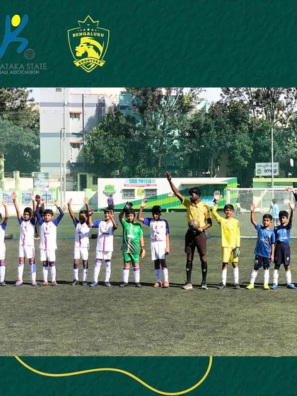 The team lines up with hands raised, a sign of unity and readiness before the match begins.