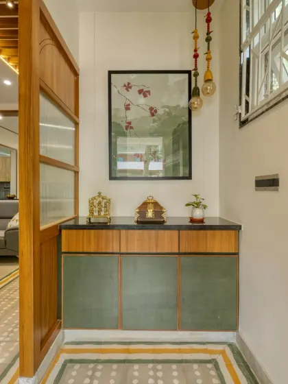 The foyer sets the tone for the home with handcrafted cement tiles, a custom console in green and wood, and vintage-inspired lighting.