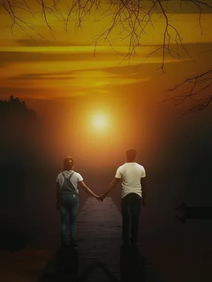 A dramatic sunset silhouette as a couple walks towards the light. This artistic pre-wedding shot symbolizes the beautiful journey you are beginning together.