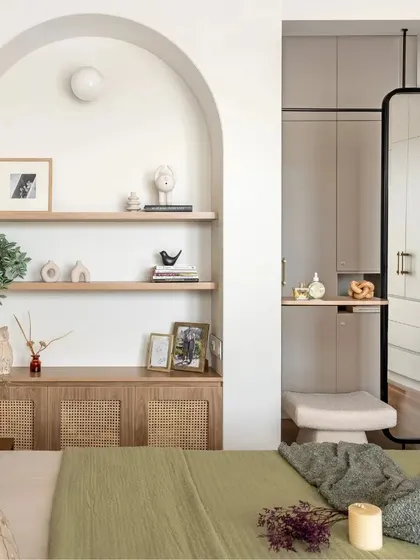 A cozy bedroom retreat that is both functional and stylish, featuring a niche that acts as a centerpiece and a two-way mirror that adds a touch of modern sophistication.