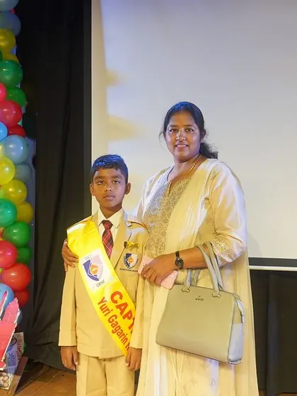 A student leader stands proudly with his mother, showcasing the family support that is integral to our students' success. The Investiture Ceremony is a celebration for the entire school community.