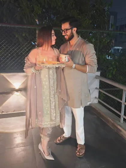 Celebrating their bond under the evening lights. This shot, with the couple holding a decorative thali, brings a festive and traditional feel to their outdoor pre-wedding photoshoot.