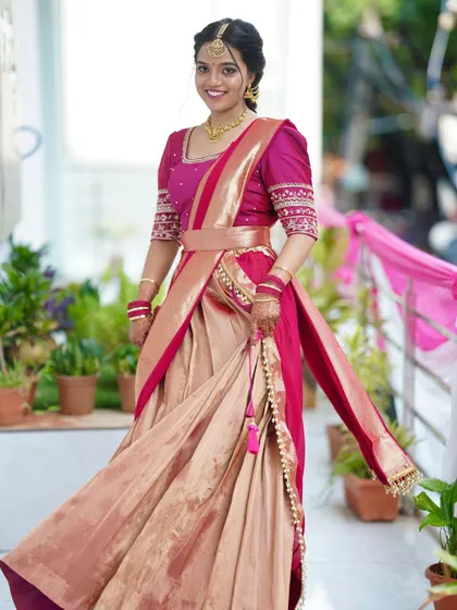 This full-length shot shows the complete traditional look. The makeup and hairstyle are designed to perfectly complement the elegance of the half saree for a timeless appeal.