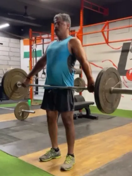 An athlete demonstrating a powerful shrug at the top of a snatch pull. This "finishing the pull" is critical for getting maximum height on the bar before dropping under it.