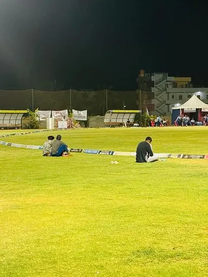 The ground viewed from the boundary line at night, showing the full spread of the floodlights and the event setup.