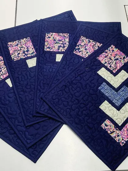 The set of navy blue placemats fanned out to show the repeating design.