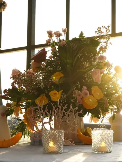 The golden hour light hitting this floral and citrus centerpiece creates a magical glow. I always consider the natural light when designing an event space.
