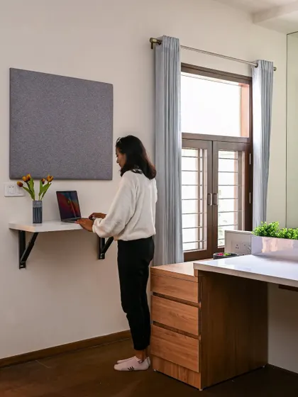 "The essence of interior design will always be about people and how they live." Here, a team member tests out a standing desk setup in a home office.