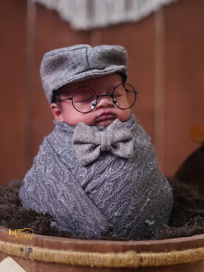 A dapper little scholar in a grey tweed outfit with a bow tie and glasses. This vintage-inspired theme is full of charm and character.
