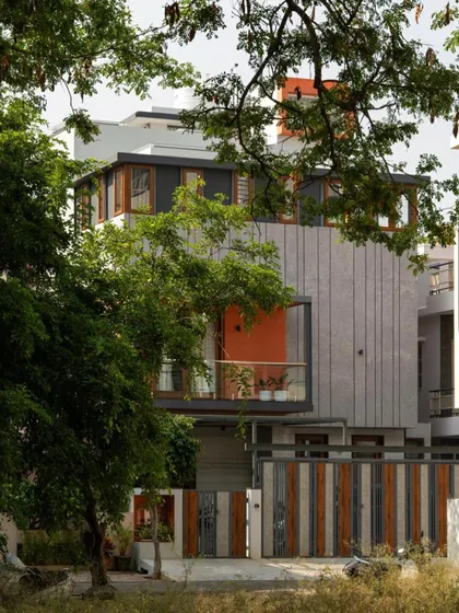 The 'Chirantana' residence is designed in harmony with its surroundings. The bold grey and orange facade stands out, yet the presence of mature trees on the site was considered to frame the view of the home.