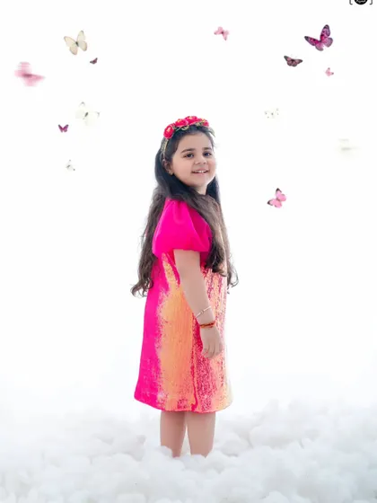 In a world of white whispers and butterfly wings, she blooms in pink magic. A dreamy, ethereal portrait.