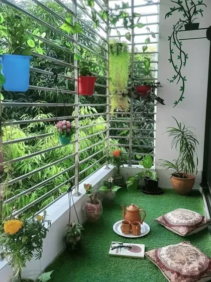This cozy corner shows the beauty of floor seating. With just a few comfortable cushions on an artificial grass floor, this small, grill-enclosed balcony becomes a perfect spot for enjoying a quiet cup of tea surrounded by greenery.