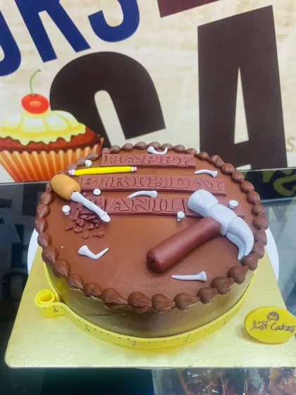A 1.5kg chocolate cake with simple fondant tool decorations, perfect for a handyman or builder.