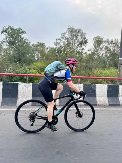 A side profile of a member riding with a backpack, prepared for a long journey.