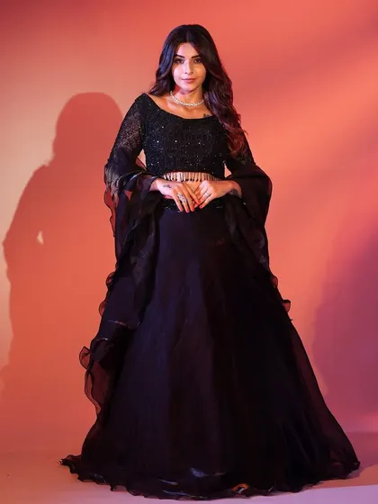 You can never go wrong with a classic black lehenga. This one features subtle sequin work and dramatic flared sleeves, giving it a touch of modern elegance for any occasion.