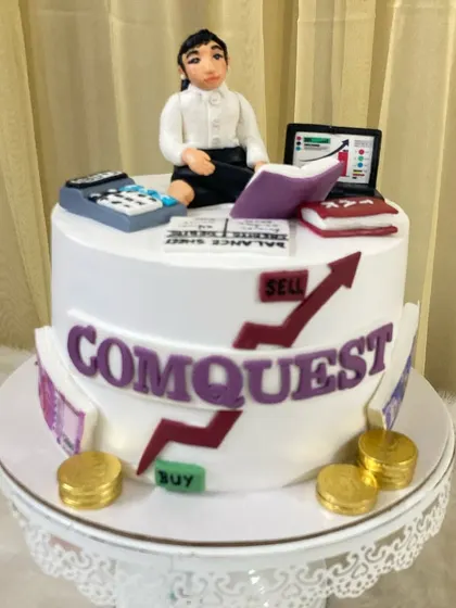 A cake for a financial wizard! This stock market-themed cake features a handcrafted fondant investor, a balance sheet, and edible currency to celebrate a big win.