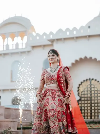 The bride's grand entrance, framed by cold-pyro fireworks. Her confident smile and the celebratory atmosphere make for a stunning and powerful portrait.