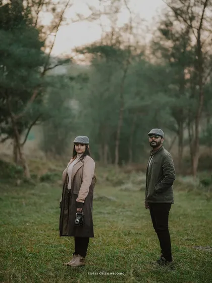 Ananthu and Sarga's vintage-themed shoot in a misty forest. The unique styling with classic hats and a vintage camera adds a layer of storytelling to their couple portraits.
