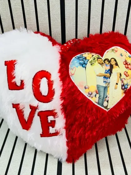A heart-shaped "LOVE" cushion that can be personalized with a photo. The fluffy red and white material makes it extra cozy.