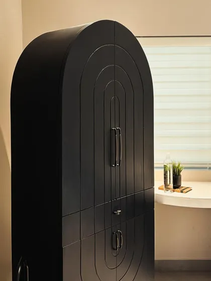 A full view of the black arched storage cabinet, showcasing its unique shape and commanding presence in the workspace.