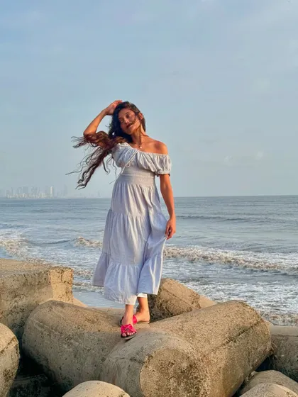 A joyful, windy moment on the rocks by the sea. Embracing the elements and having a laugh is what it's all about.