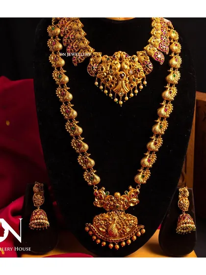 A complete temple jewellery set with a choker and long haram. The peacock and goddess motifs are classic elements of South Indian bridal jewellery.