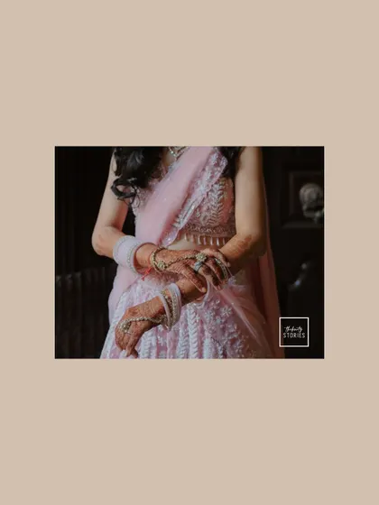 A detailed shot focusing on the bride's hands, adorned with intricate jewelry and bangles, showcasing the fine details of her bridal look.