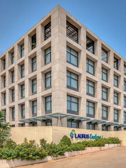 The gridded facade of Laurus Labs creates a strong architectural identity, with deep-set windows that provide shade and large floor plates for flexible office layouts.