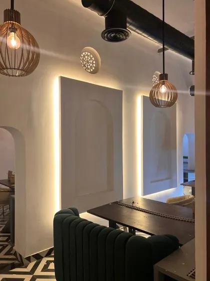 This corner of the restaurant showcases our use of ambient lighting to create an intimate dining atmosphere. The arched wall niches and geometric floor tiles add layers of texture and visual interest to the space.