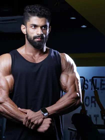 A simple pose in a tank top, showing the arm and shoulder development that provides a powerful frame. This is the foundation of a strong upper body.