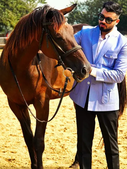 A gentleman's pursuits. Our light blue safari jacket is pictured here in a rustic setting, proving that great style is at home anywhere. The jacket's unique design makes it a versatile statement piece.