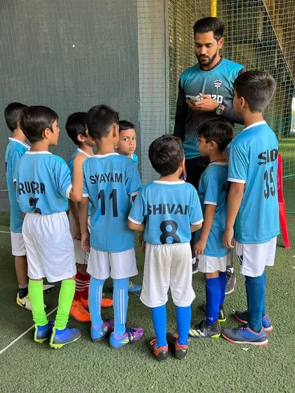 A coach giving a team talk to the U-9s, ensuring every player is on the same page before a match.