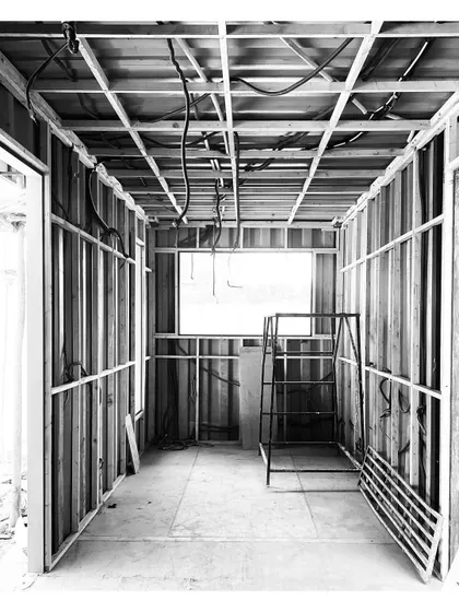 An interior view showing the wooden framing and paneling being installed inside a container. This framework will hold insulation, wiring, and the final wall finishes.