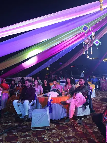 Guests seated and enjoying the evening performances. The combination of colorful overhead decor and ambient lighting creates a magical atmosphere.