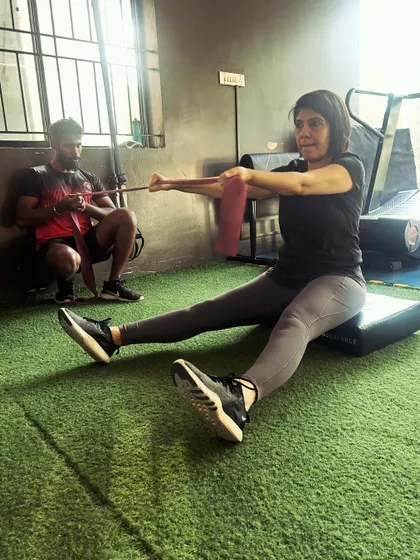 A seated row with a resistance band, an exercise that can be used for both strengthening and active mobility of the upper back.