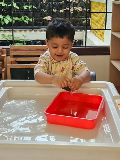 Water play is a favorite for sensory exploration. This child is discovering concepts like floating and sinking while developing his fine motor skills, all in a joyful and engaging setting.