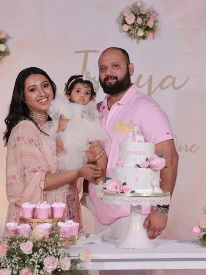 A lovely family portrait at a soft, elegant first birthday party with a pink and white floral theme.
