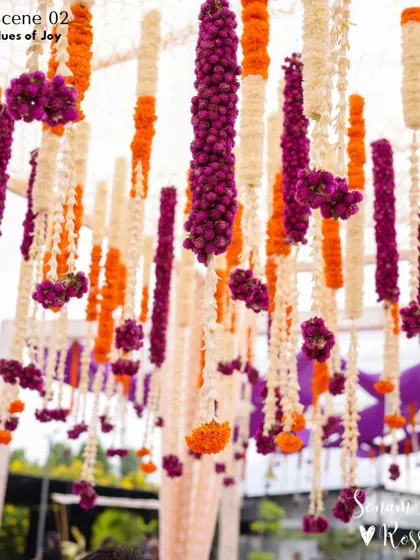 We love playing with color. For this Haldi, we created a stunning overhead floral installation using strings of purple, orange, and white flowers, adding a vibrant and joyful touch to the decor.