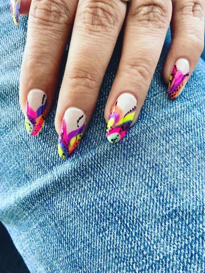 This abstract nail art is a burst of color and creativity. We used a vibrant mix of neon pink, yellow, and purple to create a graffiti-style design on long nails, perfect for a bold and artistic statement.