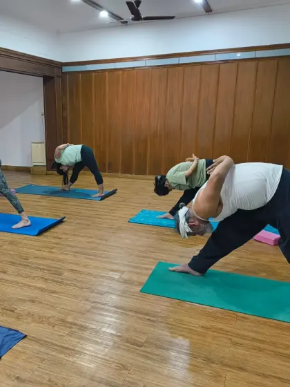 Change happens when we learn to surrender. Students in Parsvottanasana, or pyramid pose, a deep forward bend that teaches us to let go.
