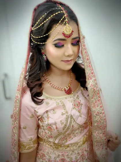 A close-up of a modern bridal look with a focus on dramatic eye makeup using purple and pink tones. Students learn color theory and blending techniques to create custom looks for their clients.