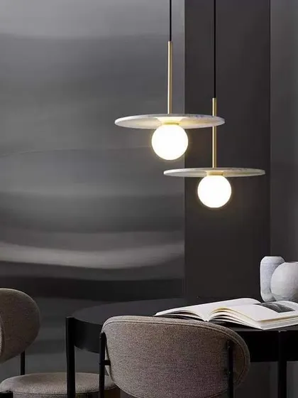 A minimalist pendant with a flat marble disc and a glowing globe. This design is perfect for adding a touch of sophistication over a dining table or reading nook.