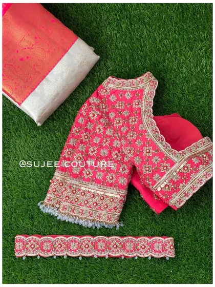 A complete set featuring a bright pink blouse with all-over floral embroidery in silver and gold. The set includes a matching embroidered vaddanam (belt) to complete the look.